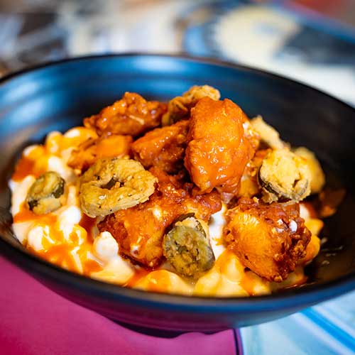 Mac and cheese topped with buffalo chicken and fried jalapeños