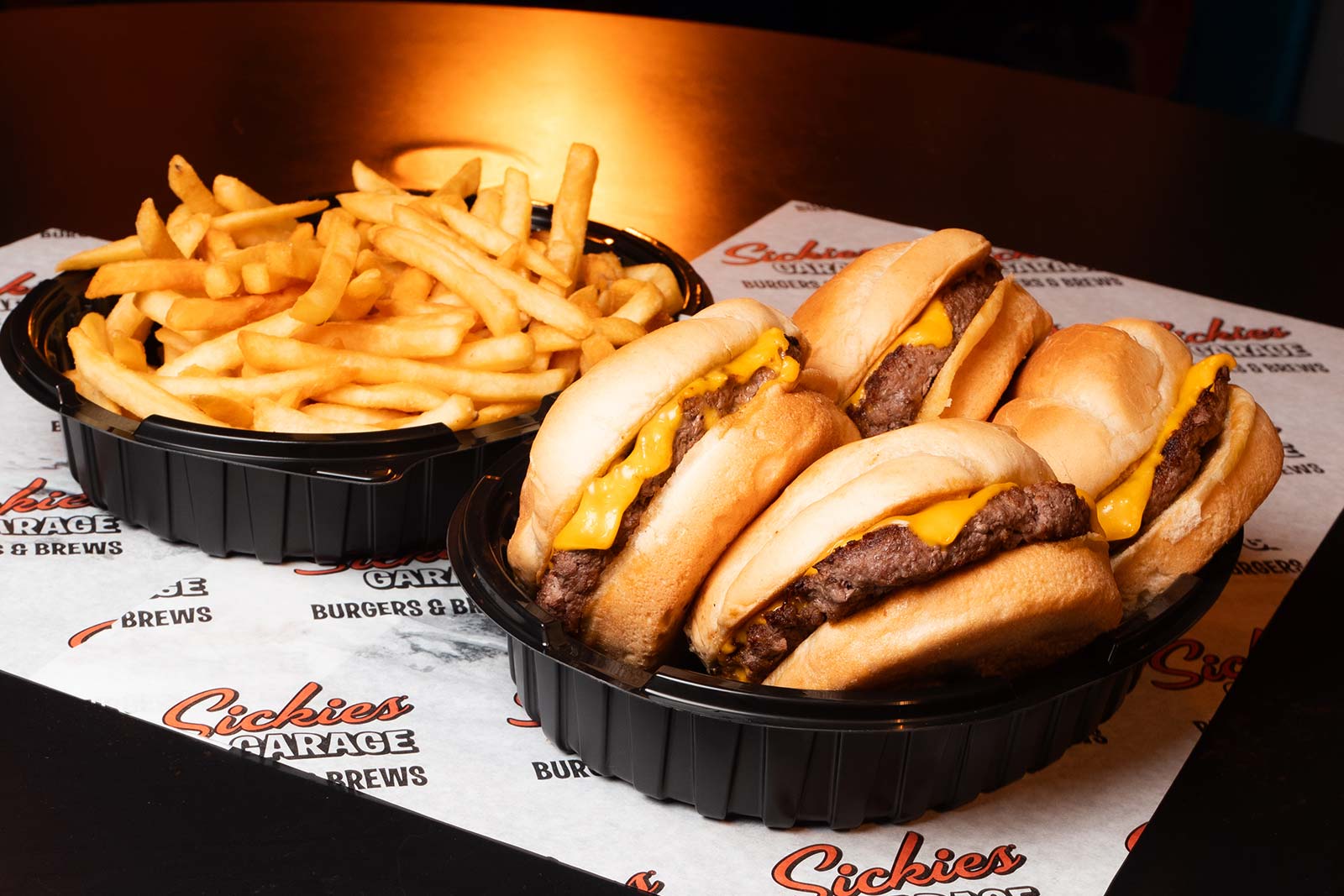 5 large bacon burgers on a skewer surrounded by fries